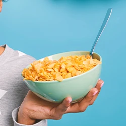 A woman holding a bowl of cereal with high levels of glyphosate