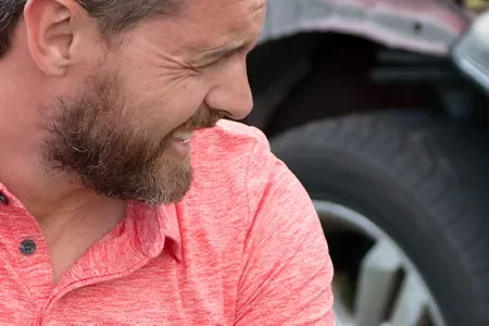 Upset driver outside his car after an accident