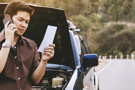 A man calling someone after having a car accident