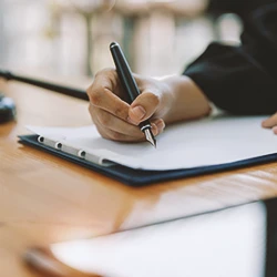 A lawyer writing down the burden of proof for a roundup claim on paperwork