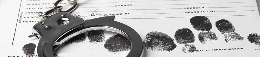 A close up shot of handcuffs and criminal records
