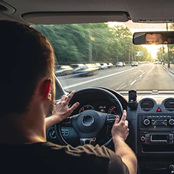 An image of a man inside a car who is driving fast