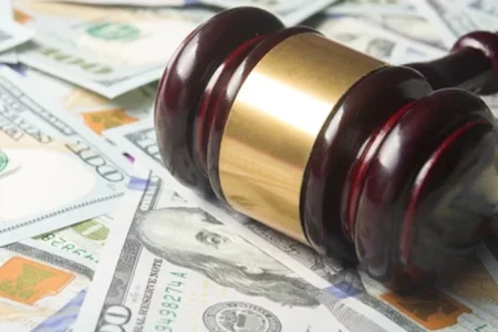 A court gavel and money settlement