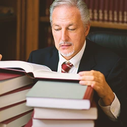 A lawyer looking up the definition of criminal threats in a law book