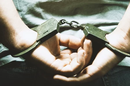 A person handcuffed behind the back
