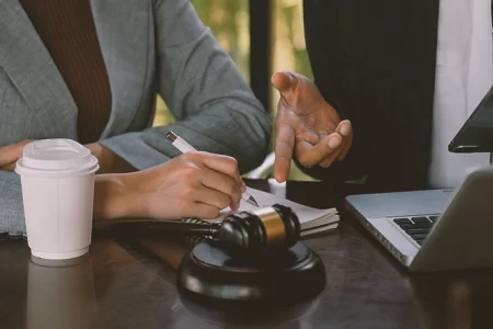 Two lawyers arguing while looking at a notebook