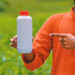 A gardener pointing to weed killer with glyphosate