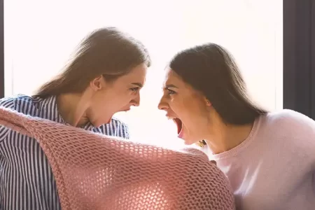 Two women screaming and pulling clothes