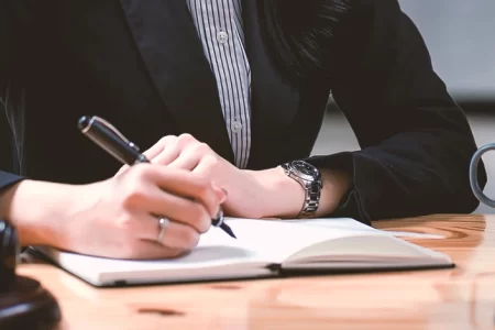 A lawyer writing down on a notebook