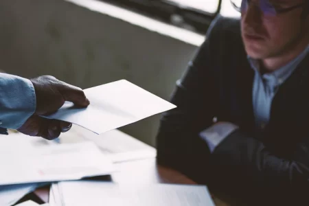 A lawyer passing a piece of paper to a client