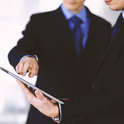 Two businessmen discussing a clipboard