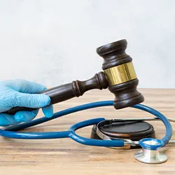 hands with medical gloves holding a gavel