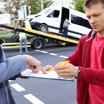 man and woman signing papers after a car accident