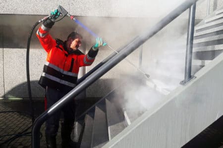 Man pressure washing steps with recalled pressure washer