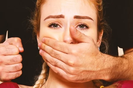 Someone holding a girl's mouth shut